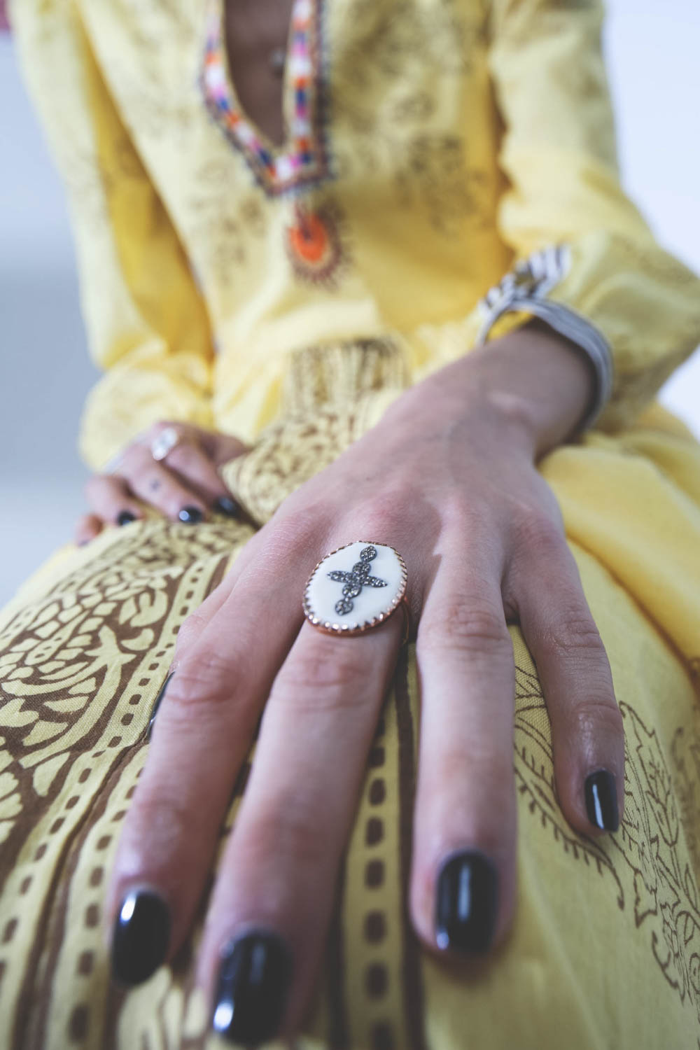 Robe longue manches longues en voile de coton jaune imprimé et brodé Alix of Bohemian. Porté avec des bijoux bohème. 