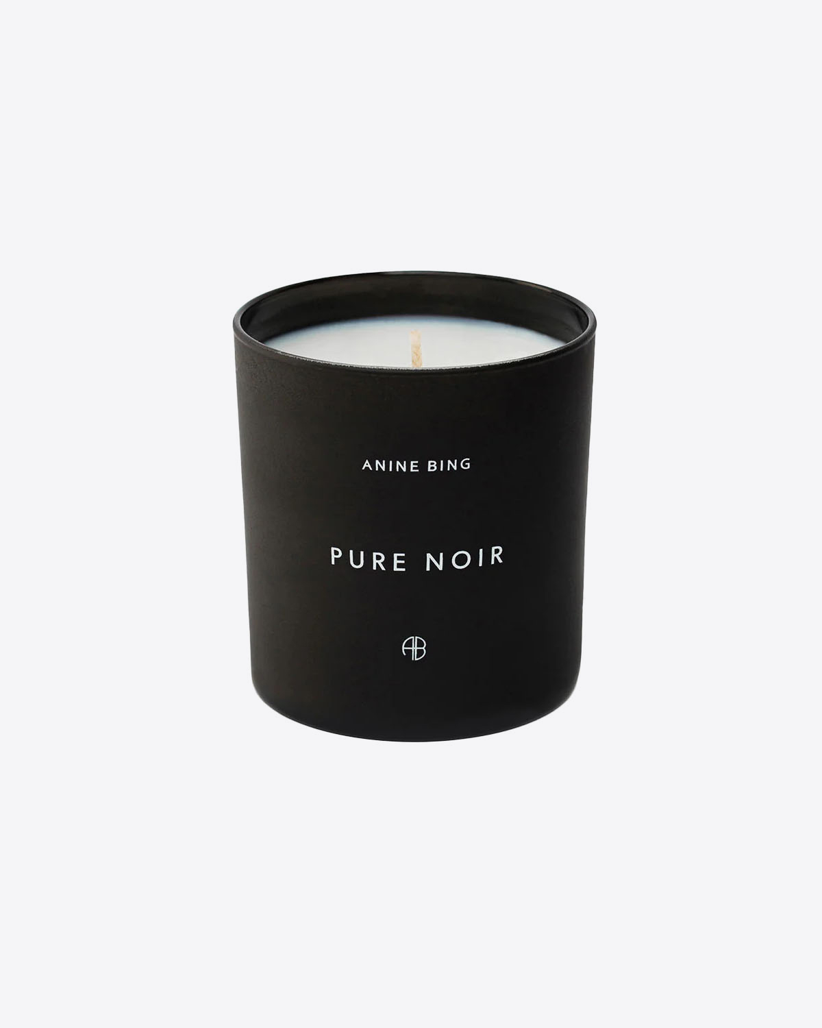 Produit Bougie Pure Noir Anine Bing. Mélange de rose baccara noire, de papyrus et de safran épicé, avec des notes sombres de bois de gaïac et d'acajou. Face.