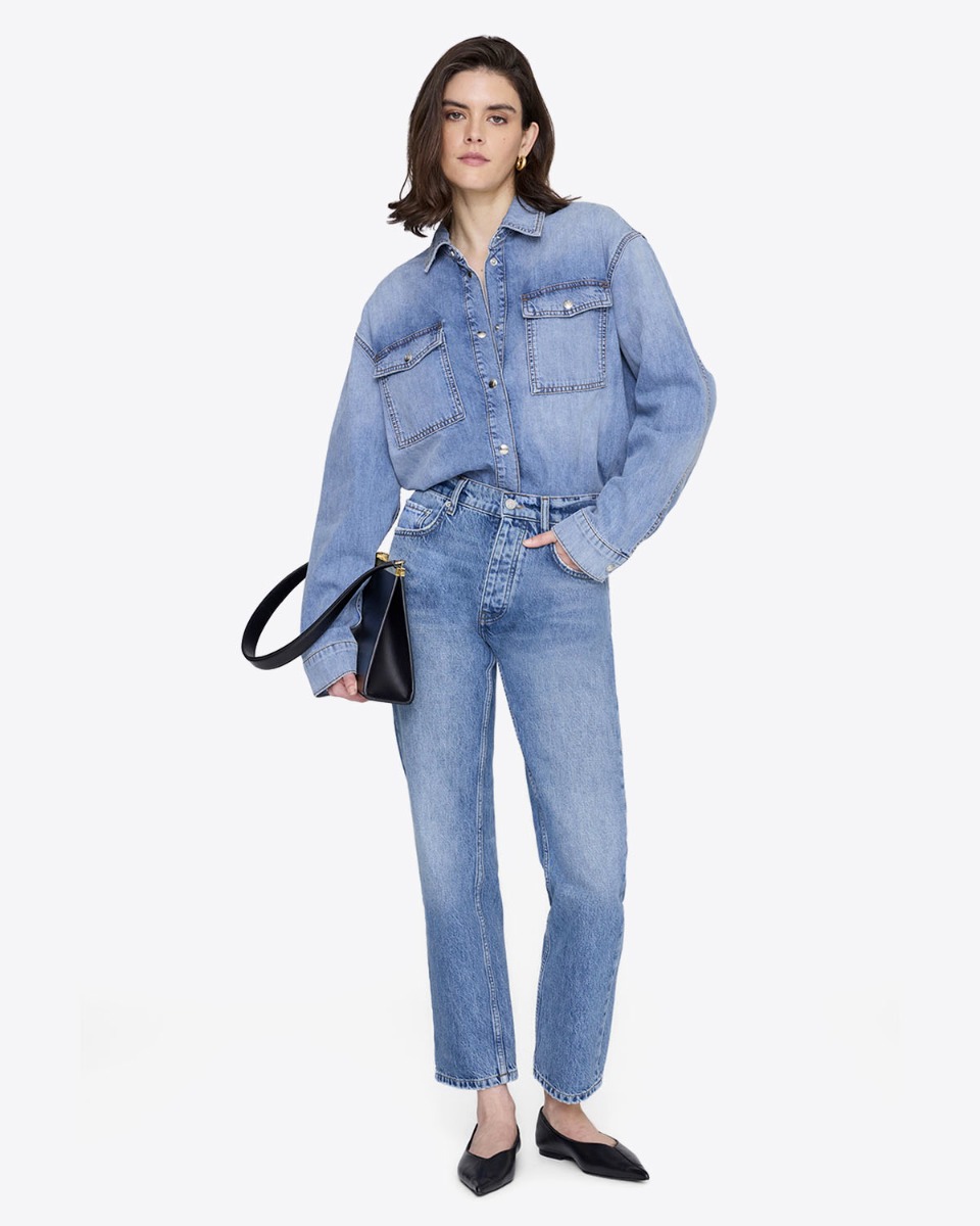 Chemise en jean Paxton Anine Bing en coton bleu d&eacute;lavage Tidal, port&eacute;e de face rentr&eacute;e dans un jean taille haute.
