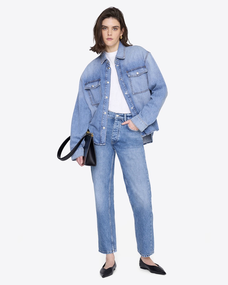 Chemise en jean Paxton Anine Bing en coton bleu d&eacute;lavage Tidal, port&eacute;e ouverte sur un tee-shirt blanc.