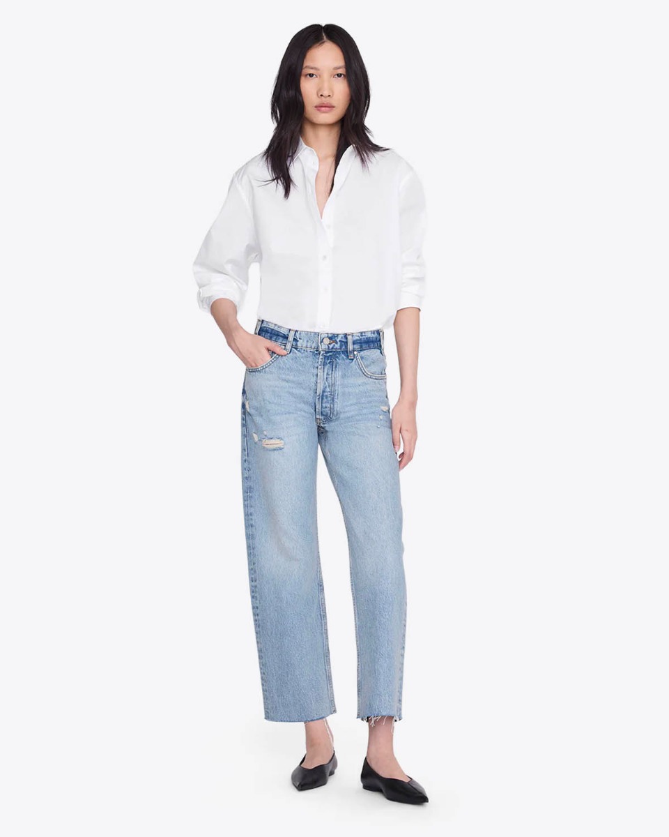 Jean droit Gavin bleu Anine Bing en denim bleu clair &laquo; Blue Reservoir &raquo;, port&eacute; de face avec une chemise blanche.