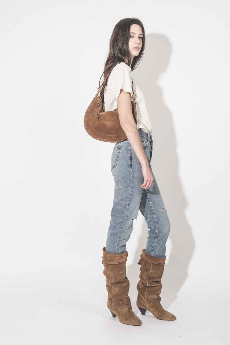 Jean taille haute slim Bruno Anine Bing en denim r&eacute;g&eacute;n&eacute;ratif bleu d&eacute;chir&eacute; aux genoux, port&eacute; de profil.