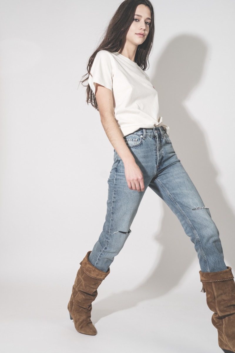 Jean taille haute slim Bruno Anine Bing en denim r&eacute;g&eacute;n&eacute;ratif bleu d&eacute;chir&eacute; aux genoux, port&eacute; avec des bottes Isabel Marant.