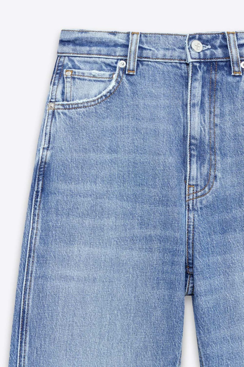 Jean taille haute ajust&eacute; Jane Anine Bing en denim bleu ciel d&eacute;lavage Cascade Blue. D&eacute;tail du d&eacute;lavage bleu ciel avec usures volontaire au niveau des poches.