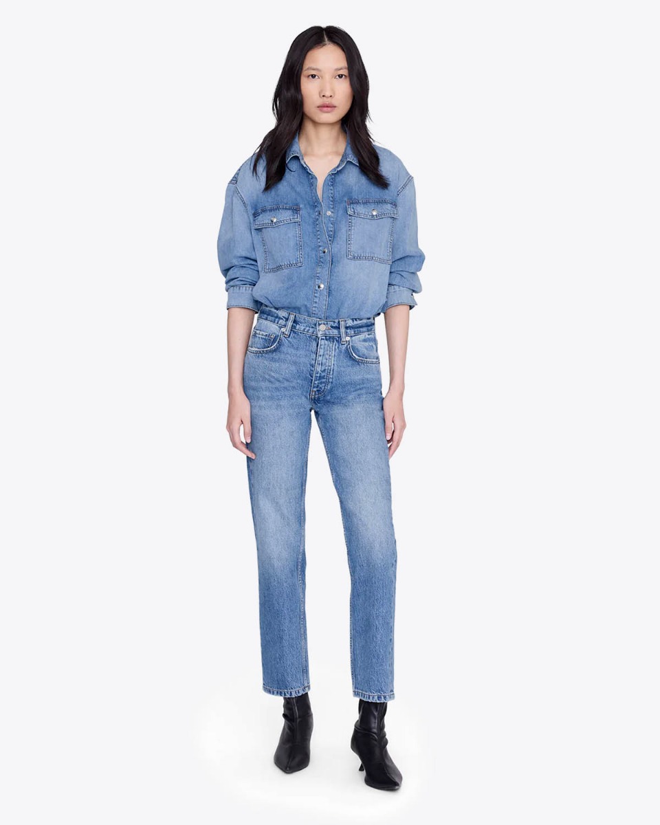 Jean taille haute ajust&eacute; Jane Anine Bing en denim bleu ciel d&eacute;lavage Cascade Blue, port&eacute; de face avec une chemise en jean assortie.