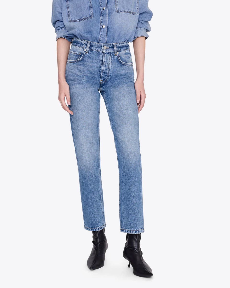 Jean taille haute ajust&eacute; Jane Anine Bing en denim bleu ciel d&eacute;lavage Cascade Blue, port&eacute; de face avec des boots en cuir noir.