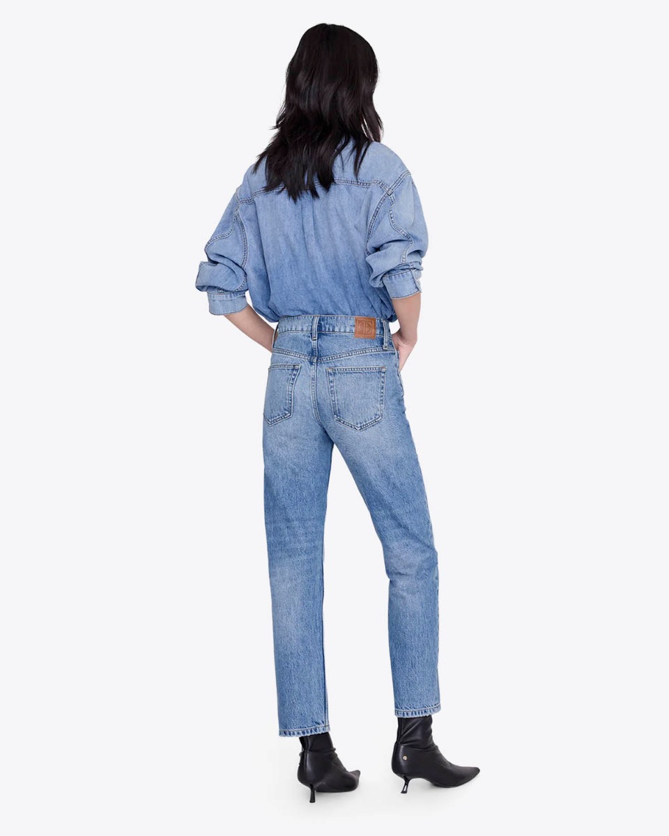Jean taille haute ajust&eacute; Jane Anine Bing en denim bleu ciel d&eacute;lavage Cascade Blue, port&eacute; de dos avec une chemise en jean.