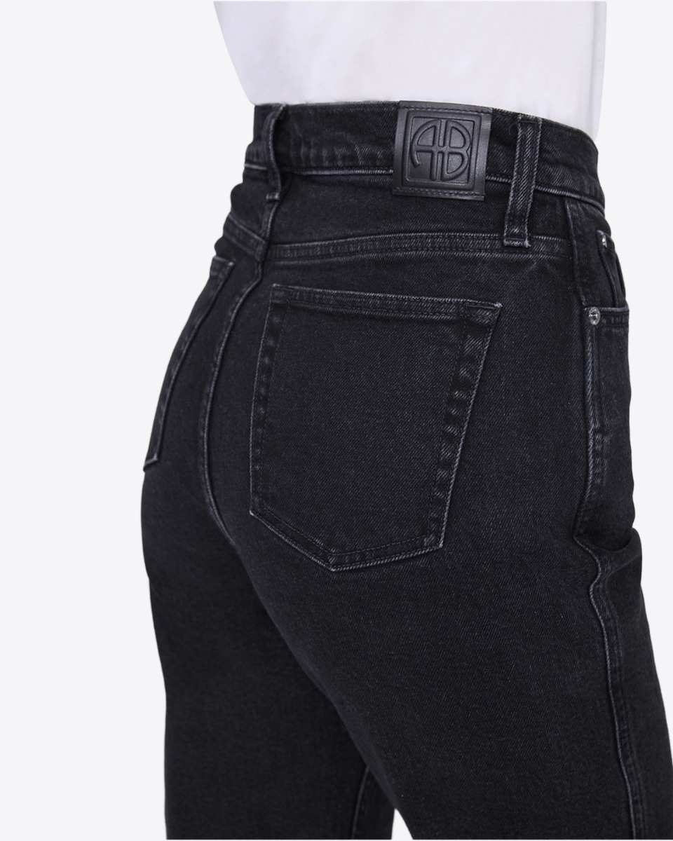 Jean taille haute Jane Anine Bing en denim noir vintage, port&eacute; de dos. D&eacute;tail des poches arri&egrave;res.