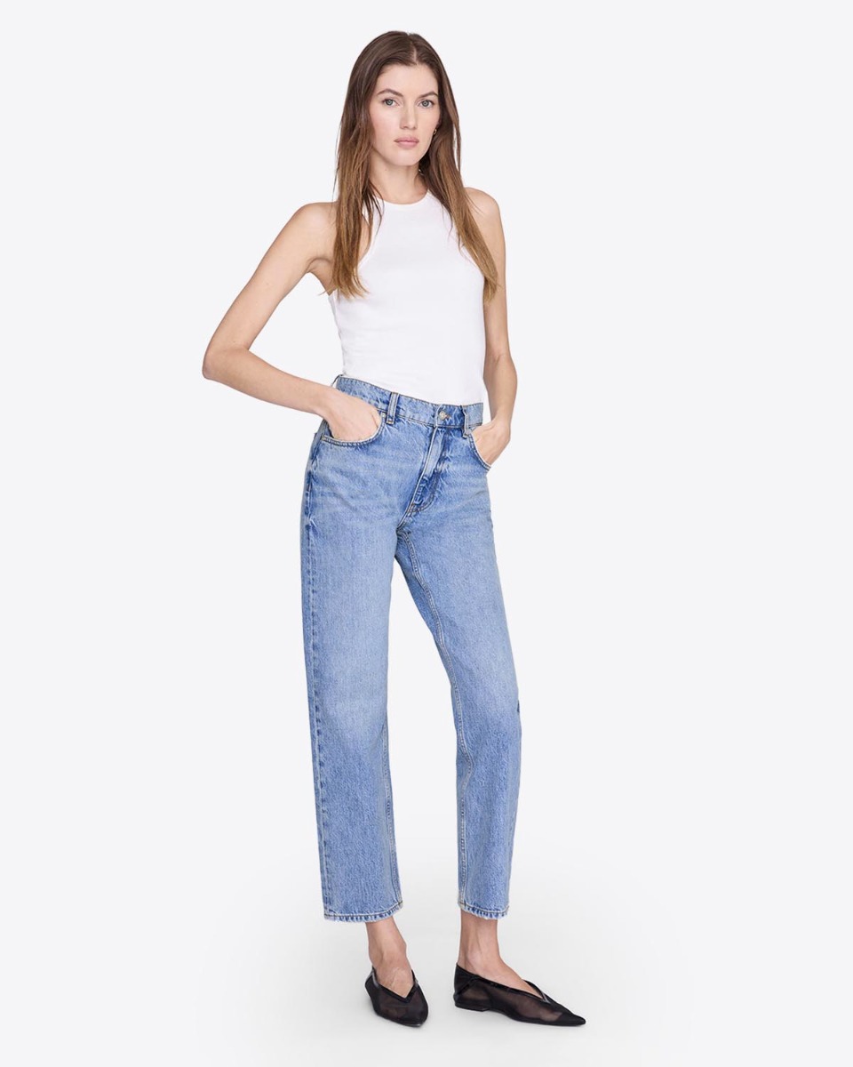 Jean Kate Anine Bing en denim bleu clair &laquo; Arbor blue &raquo;, port&eacute; de face avec un d&eacute;bardeur blanc.