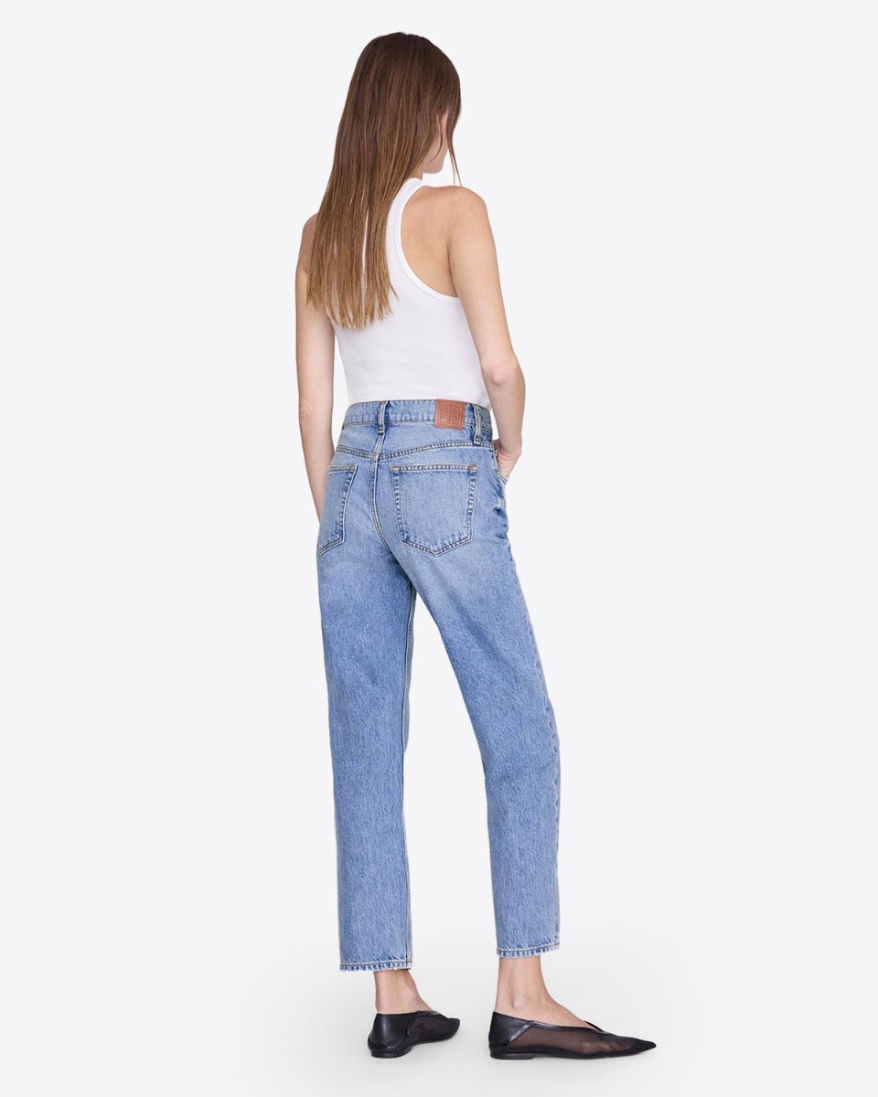Jean Kate Anine Bing en denim bleu clair &laquo; Arbor blue &raquo;, port&eacute; de dos avec un d&eacute;bardeur blanc.