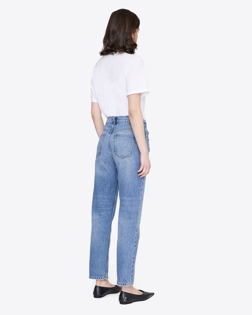 Jean taille haute ajust&eacute; Kate Anine Bing en denim bleu clair d&eacute;lavage Tidal, port&eacute; de dos avec un tee-shirt blanc.