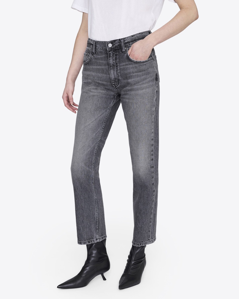 Jean taille haute Kate Anine Bing en denim gris d&eacute;lav&eacute;, port&eacute; de face avec des boots en cuir noir.