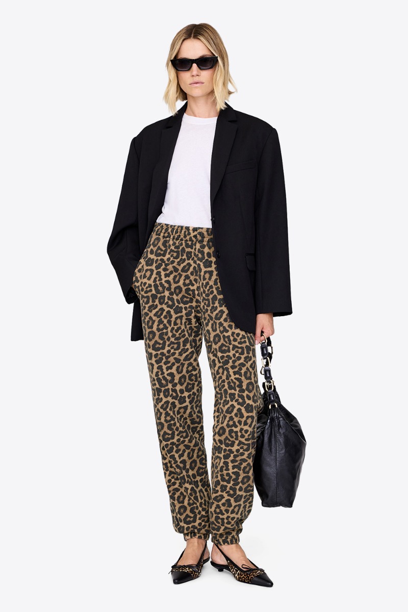 Produit Pantalon de jogging Karter Anine Bing en coton imprimé léopard, porté avec un blazer noir et des ballerines. 