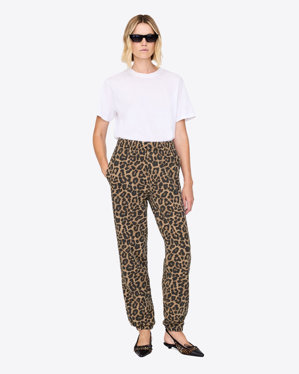 Pantalon de jogging Karter Anine Bing en coton imprimé léopard, porté de face avec un tee-shirt blanc.