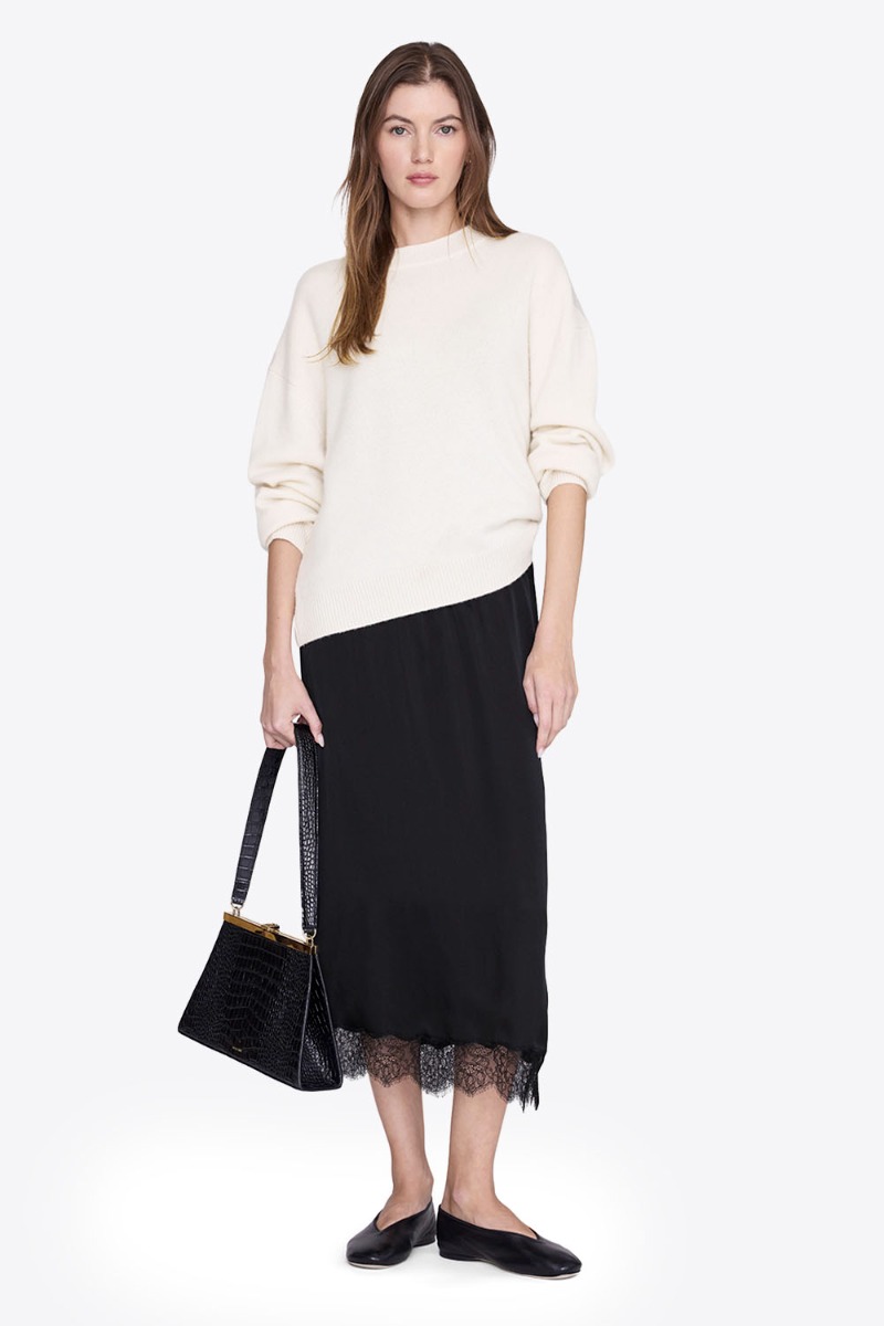 Jupe longue Shelby noire Anine Bing en satin et dentelle esprit lingerie portée de face avec un sweatshirt écru.
