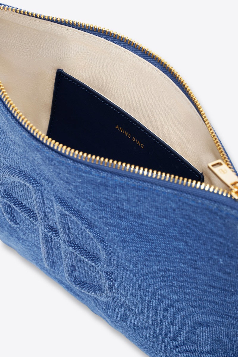 Pochette Lili Anine Bing en denim bleu Cascade. Logo en relief &laquo; AB &raquo; sur le devant. D&eacute;tails de la fermeture zipp&eacute;e, int&eacute;rieur doubl&eacute; de coton &eacute;cru et poche en cuir noir.