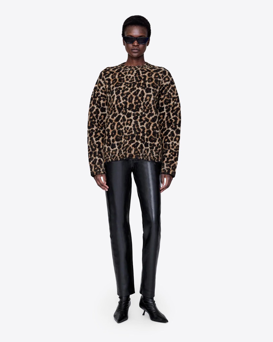 Pull Sydney Anine Bing en maille mousseuse et &eacute;paisse imprim&eacute;e l&eacute;opard port&eacute; de face sur un jean slim en faux cuir.