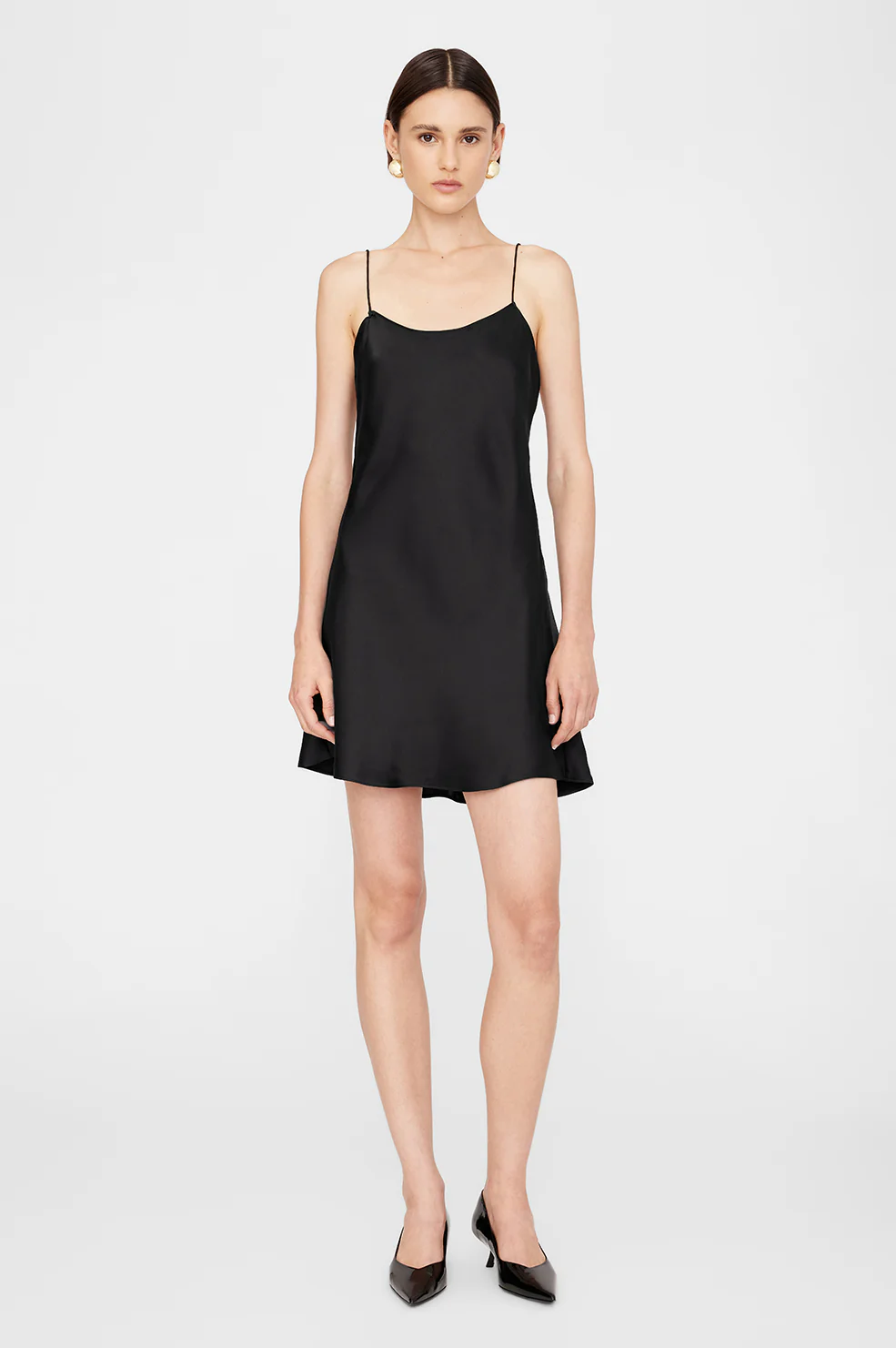 Mini robe dos nu à fines bretelles esprit lingerie en satin de soie noir Chloé Anine Bing. Porté de face.
