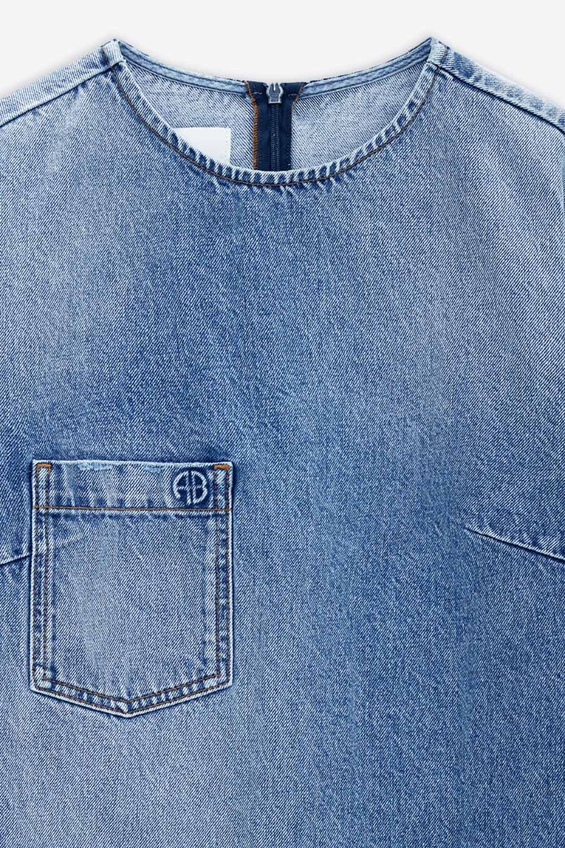 Mini-robe manches courtes Tulah Anine Bing en denim bleu ciel d&eacute;lavage Tidal. D&eacute;tails de l'encolure et de la poche plaqu&eacute;e poitrine.