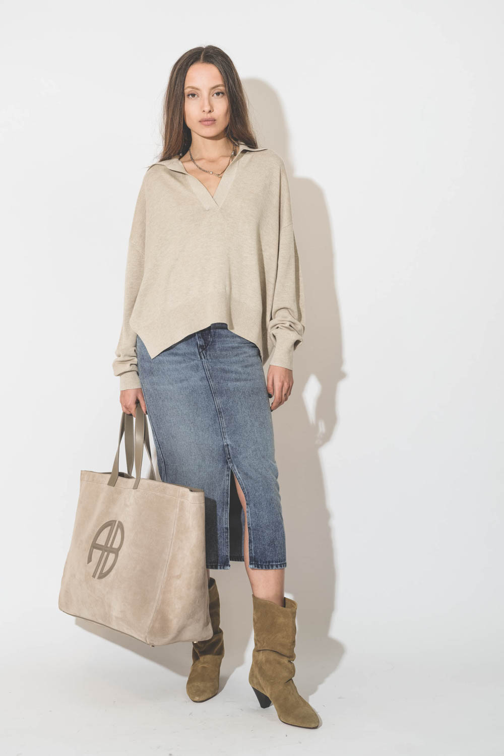 Grand cabas XL en cuir suédé beige logo AB en cuir lisse Rio Anine Bing. Porté avec un pull beige.