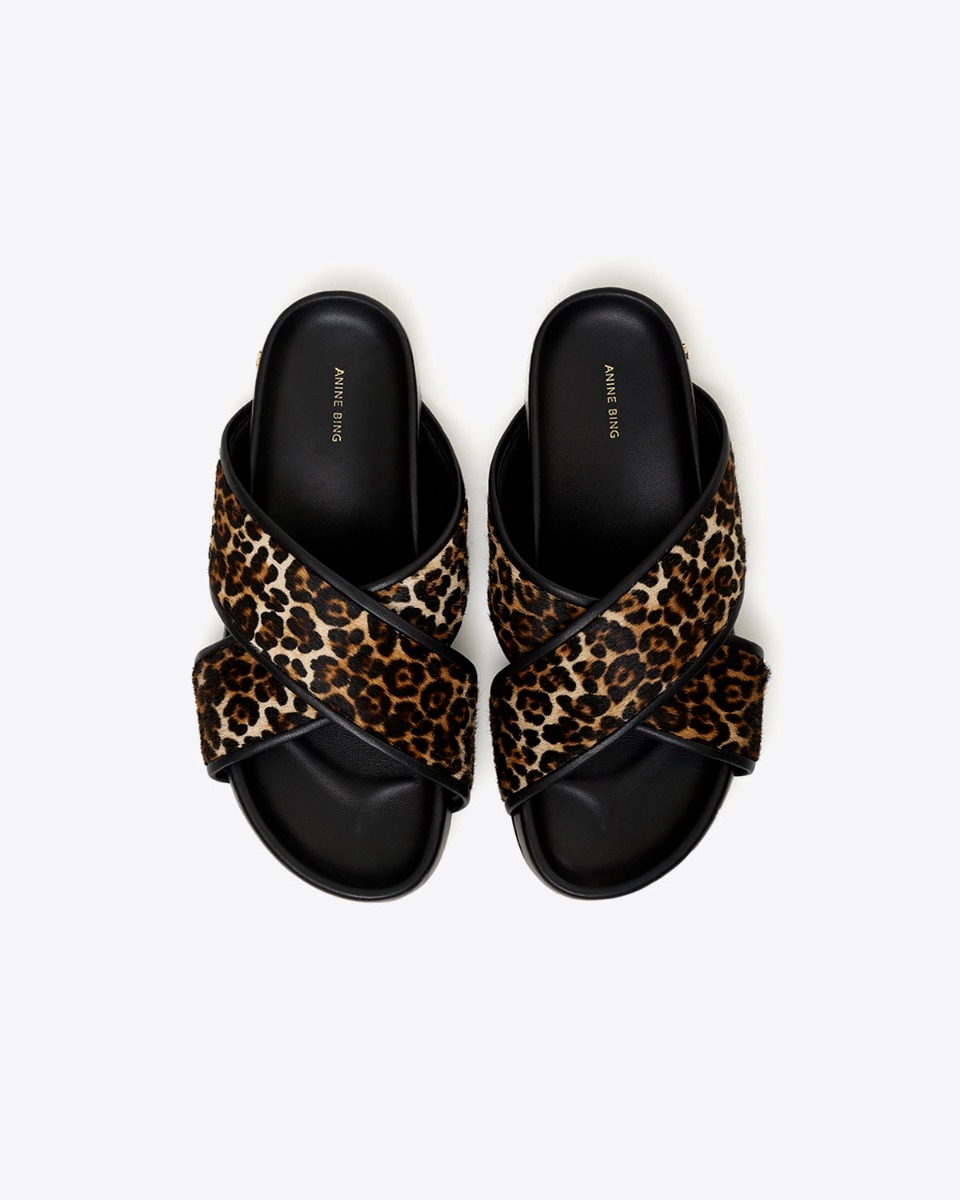 Sandales plates Emi Slide Anine Bing en cuir l&eacute;opard. D&eacute;tail de la semelle int&eacute;rieur en cuir noir. 