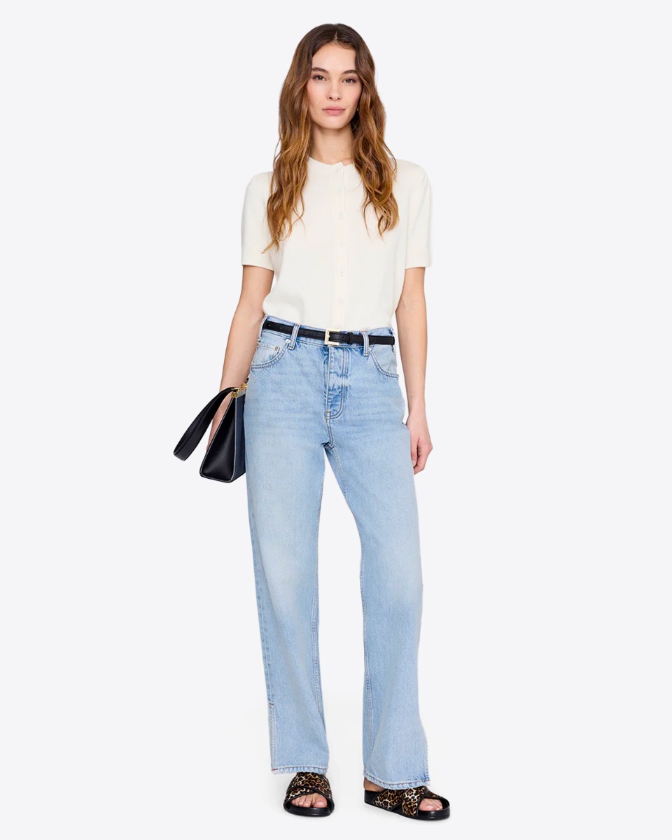 Sandales plates Emi Slide Anine Bing en cuir l&eacute;opard, port&eacute;es avec un jean bleu clair.