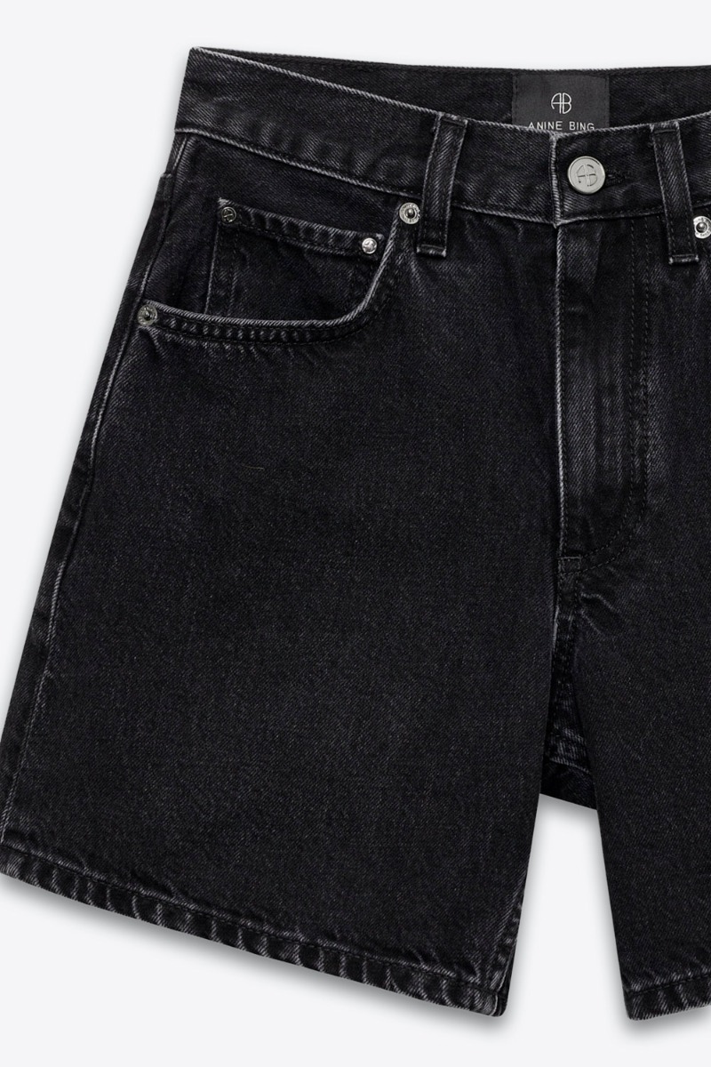 Short Delaney Anine Bing en denim noir d&eacute;lav&eacute;. D&eacute;tail du d&eacute;lavage.