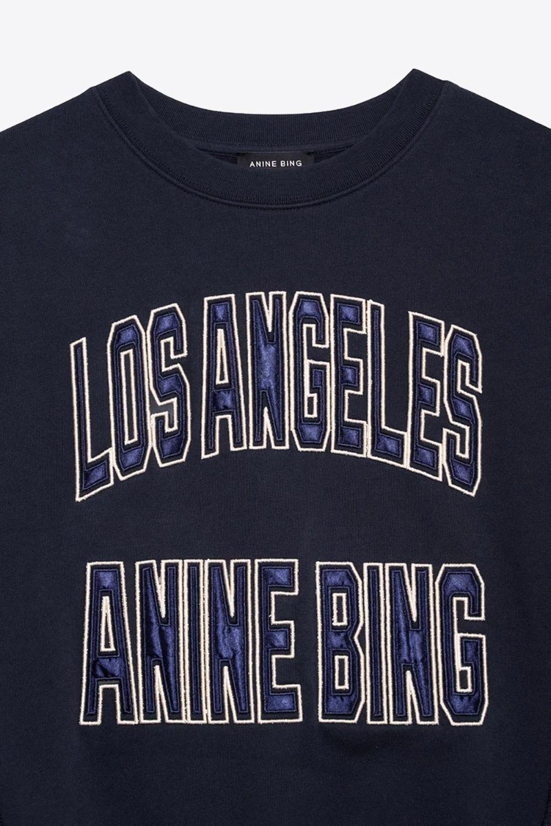 Sweatshirt Harry Shrunken Anine Bing en coton noir d&eacute;lav&eacute;, logo Los Angeles Anine Bing en satin bleu. D&eacute;tail du logo.
