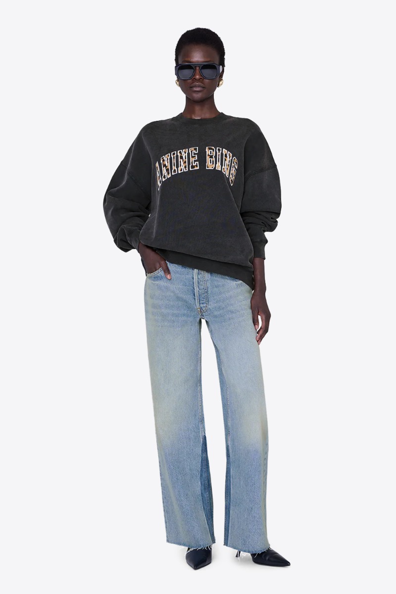 Produit Sweat-shirt Miles Anine Bing en coton noir délavé, logo léopard sur le devant. Porté avec un jean large bleu ciel.