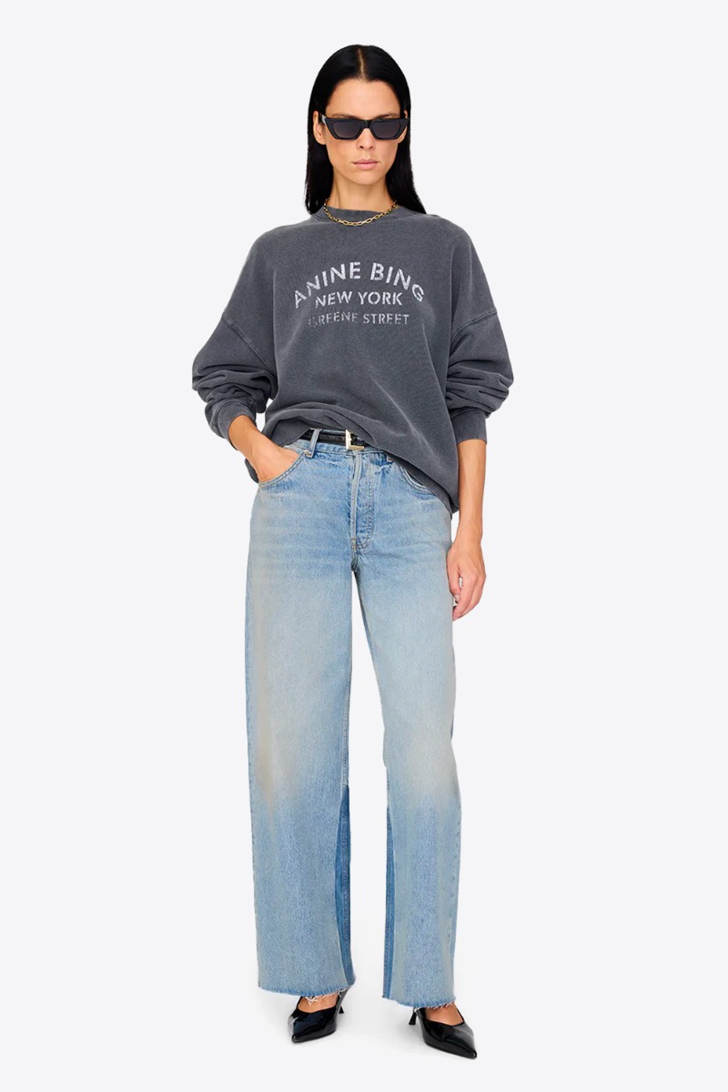 Produit Sweat-shirt Miles NY Anine Bing en coton noir délavé, porté de face avec un jean large bleu clair.
