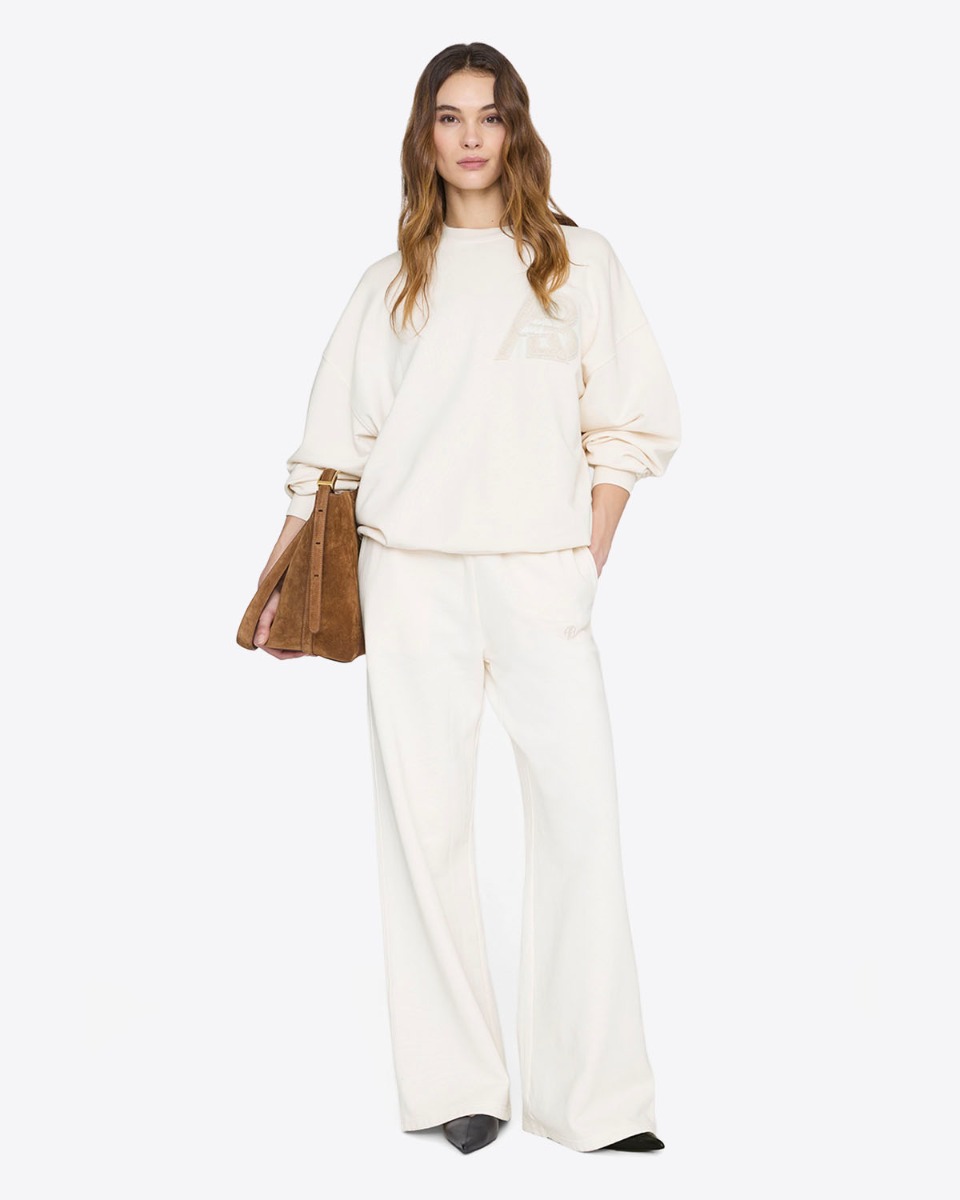 Pantalon de jogging large Kacey Anine Bing en coton cr&egrave;me, port&eacute; de face avec un sweat-shirt assorti.