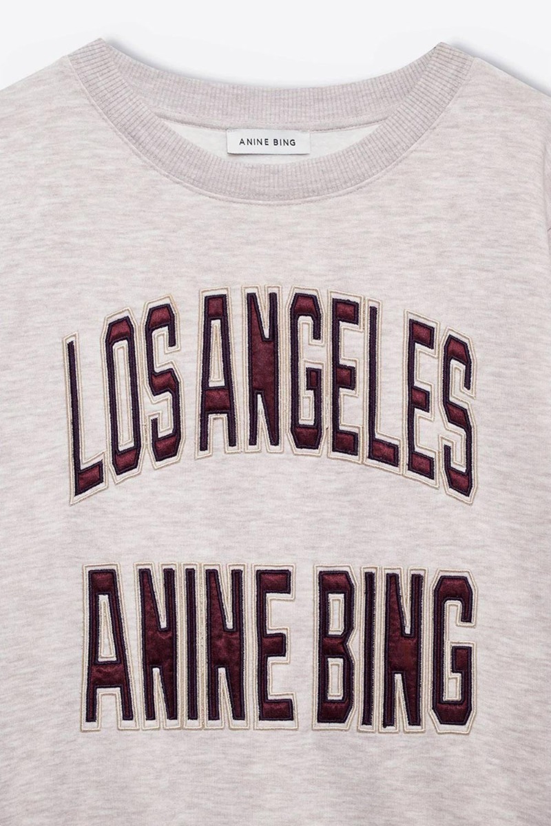 Sweatshirt Harry Shrunken Anine Bing en coton beige, logo Los Angeles. Anine Bing en satin bordeaux. D&eacute;tail du logo.