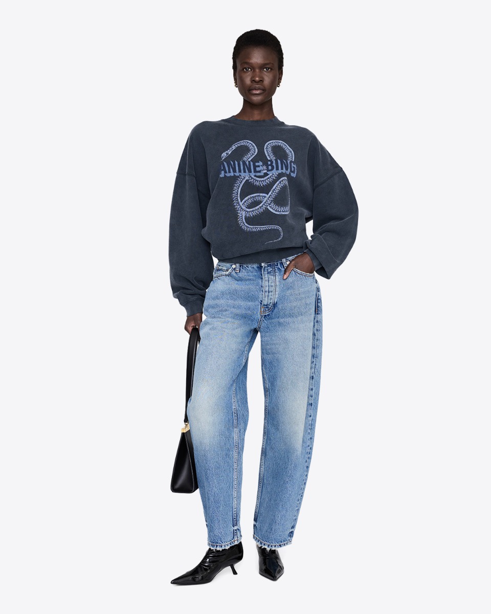 Sweatshirt Harvey Crew Snake Anine Bing en coton noir d&eacute;lav&eacute;, s&eacute;rigraphie de serpent et logo " Anine Bing ", port&eacute; de face.