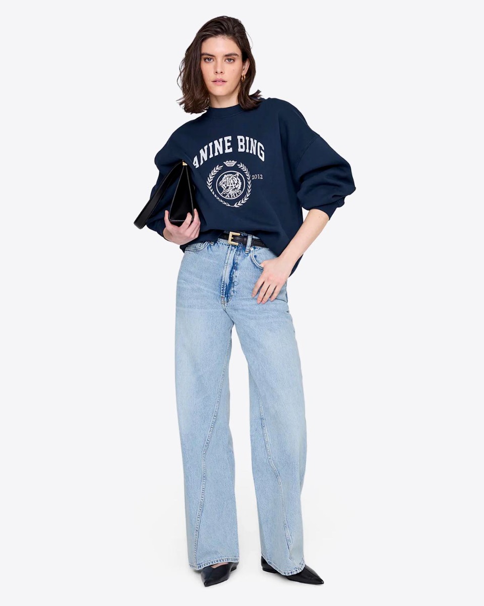 Sweatshirt Miles Collegiate Anine Bing en coton vintage black, s&eacute;rigraphie blanche brod&eacute;e coll&egrave;ge sur le devant, port&eacute; de face l&eacute;g&egrave;rement rentr&eacute; dans le jean.
