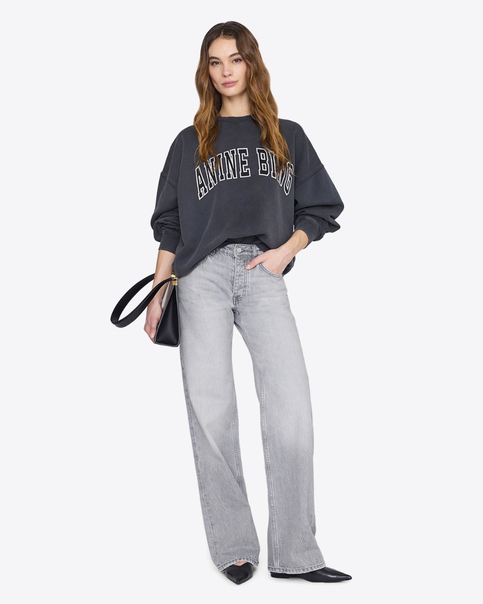 Sweat-shirt Miles Anine Bing en coton noir d&eacute;lav&eacute; logo blanc Anine Bing devant, port&eacute; de face avec un jean taille haute.