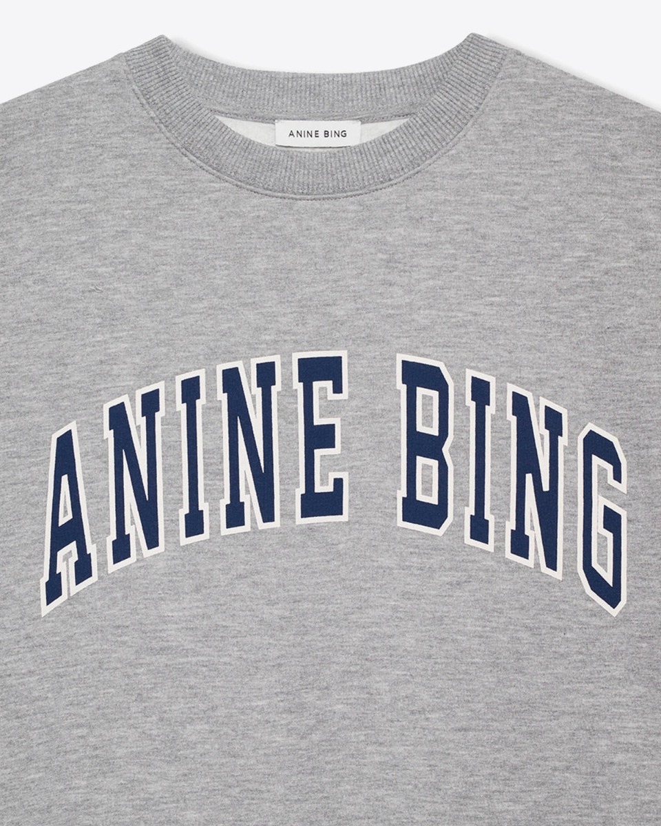 Sweatshirt encolure ronde en coton gris chiné logo marine et blanc "Anine Bing" sur la poitrine Spencer Anine Bing. Détail du logo bleu marine bordé d'un liseret blanc. 