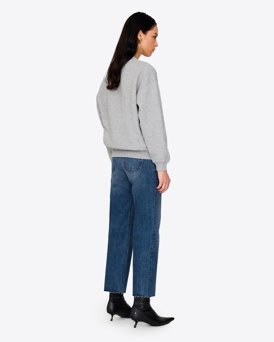 Sweatshirt encolure ronde en coton gris chiné logo marine et blanc "Anine Bing" sur la poitrine Spencer Anine Bing. Porté de dos avec un jean bleu.