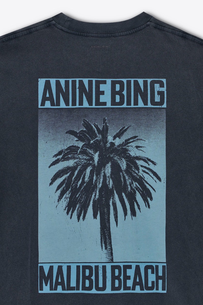 Tee-shirt Cade Palm Anine Bing en coton noir délavé. Détail de la sérigraphie bleue palmier « ANINE BING MALIBU BEACH » dans le dos.
