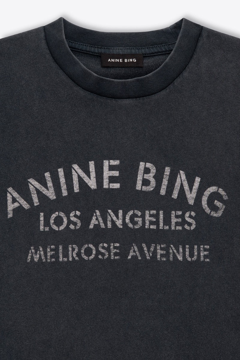 Tee-shirt Cade Melrose Stencil Anine Bing en coton noir d&eacute;lav&eacute; s&eacute;rigraphie blanche &laquo; ANINE BING &ndash; LOS ANGELES &ndash; MELROSE AVENUE &raquo; sur le devant. D&eacute;tail du col et de la s&eacute;rigraphie.