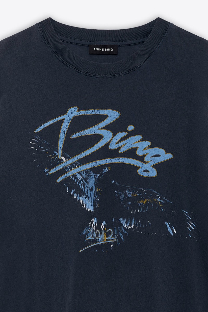 T-shirt manches courtes Kent Eagle Anine Bing en coton noir d&eacute;lav&eacute;, s&eacute;rigraphie aigle et logo &laquo; Bing &raquo; bleu. D&eacute;tail de la s&eacute;rigraphie volontairement us&eacute;e.