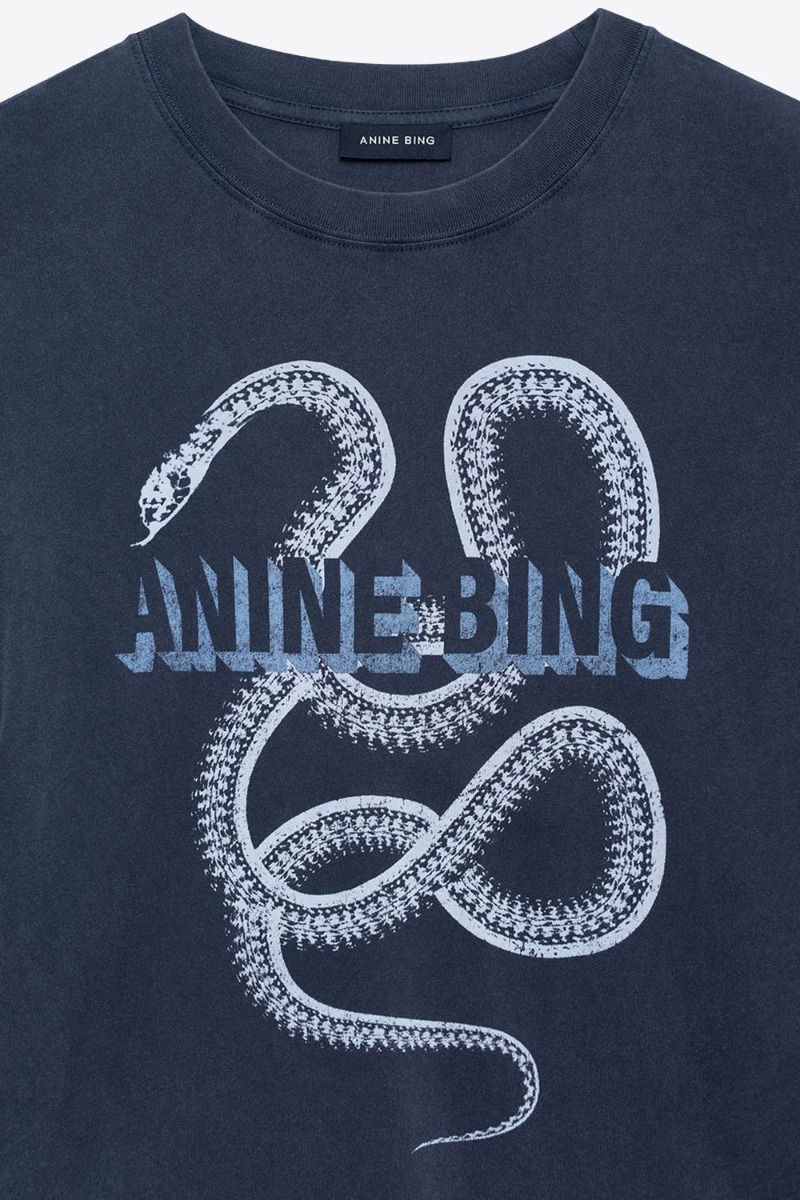T-shirt Lili Snake Anine Bing en coton noir d&eacute;lav&eacute;, s&eacute;rigraphie de serpent et logo " Anine Bing ". D&eacute;tail de la s&eacute;rigraphie blanche et bleu ciel.