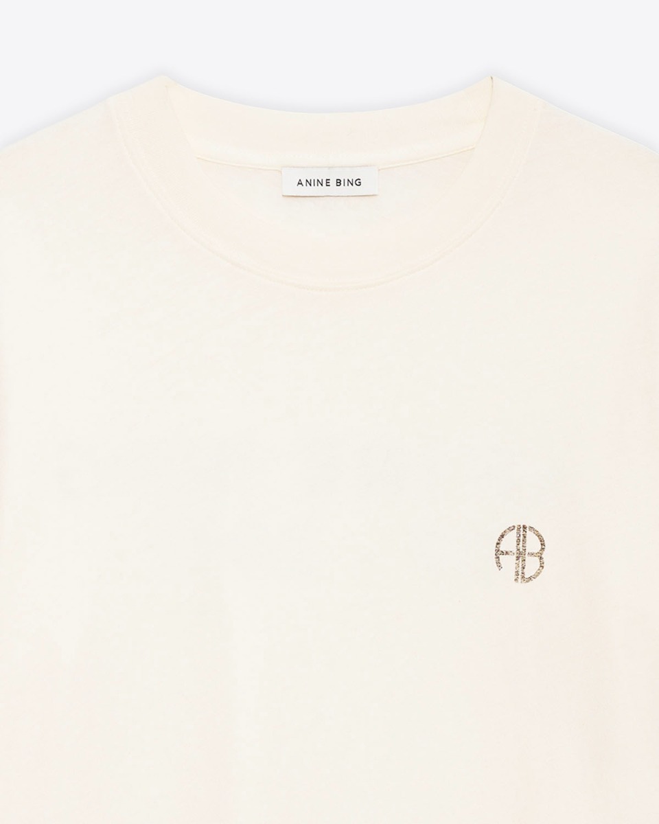 Tee-shirt manches courtes Wagner Soft Stencil Anine Bing en coton cr&egrave;me, logo AB poitrine, s&eacute;rigraphie dans le dos. D&eacute;tail du col bord-c&ocirc;te et du logo AB poitrine.