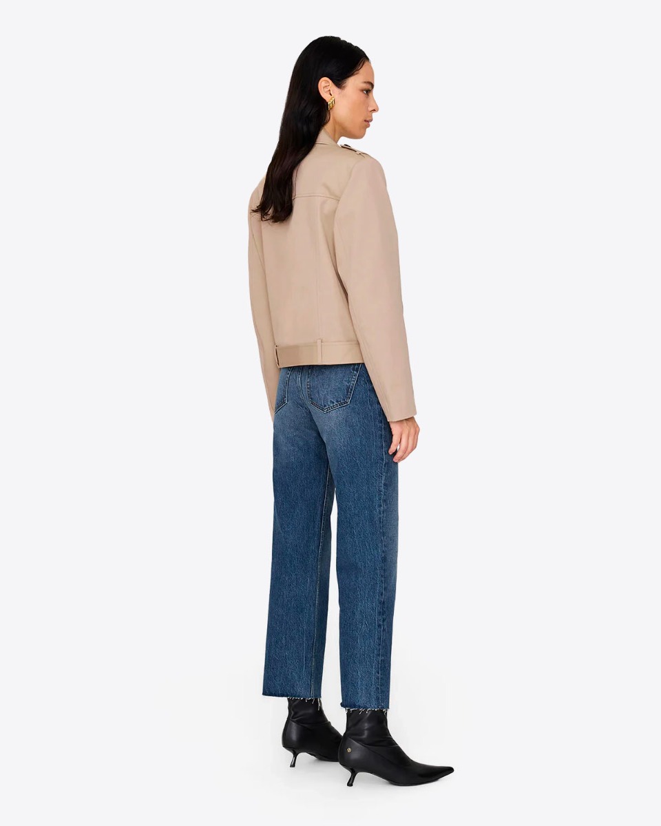 Trench court en toile beige Greer Anine Bing. Porté de dos avec un jean bleu.