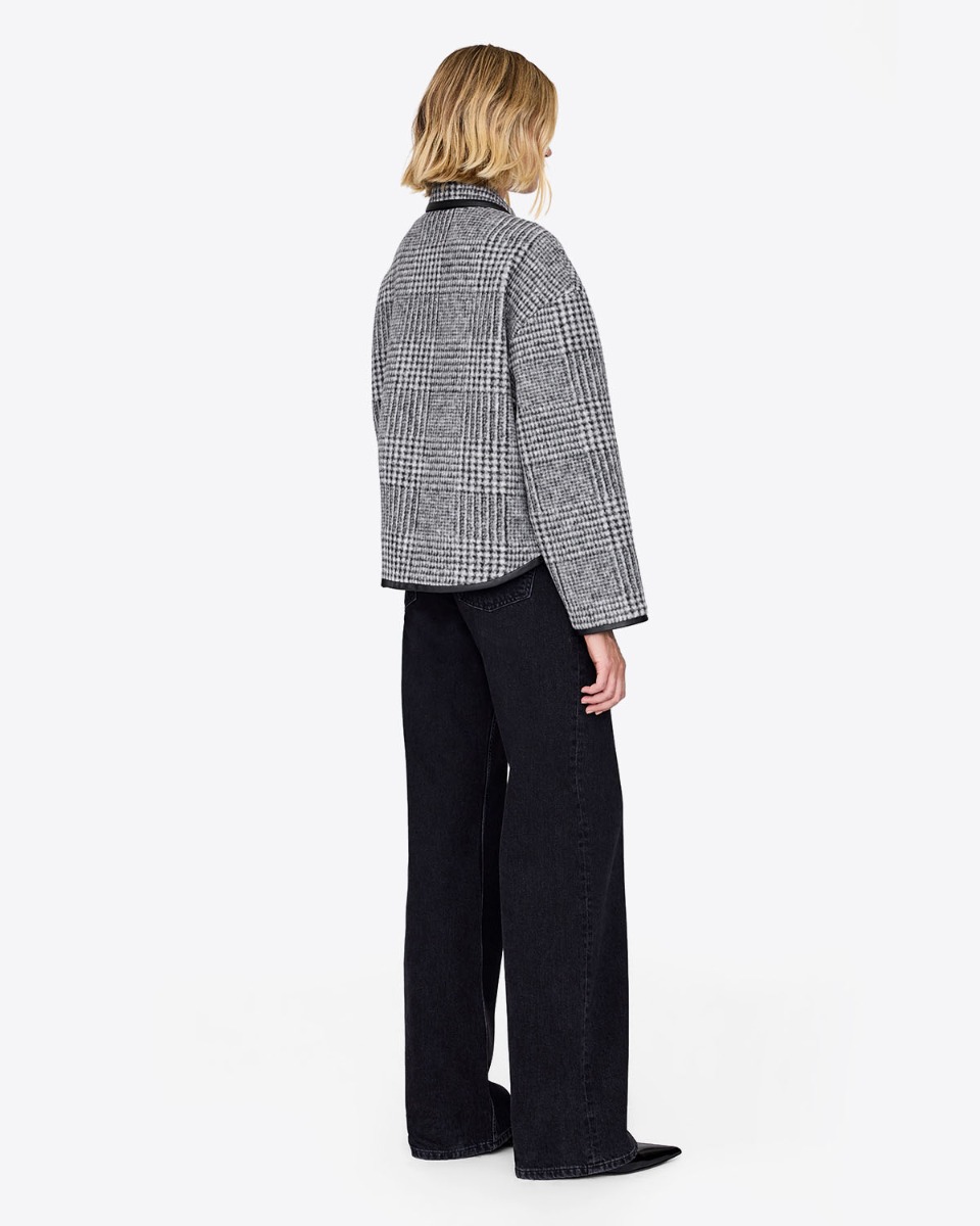 Veste Camden Anine Bing prince-de-galles noire et &eacute;cru, port&eacute;e de dos avec un jean noir.