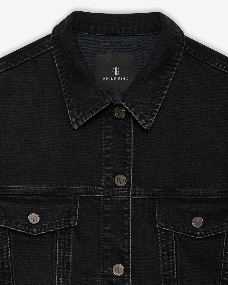 Blouson en jean raccourci Quincy Anine Bing en denim noir. D&eacute;tail du col et des bouton grav&eacute;s AB.