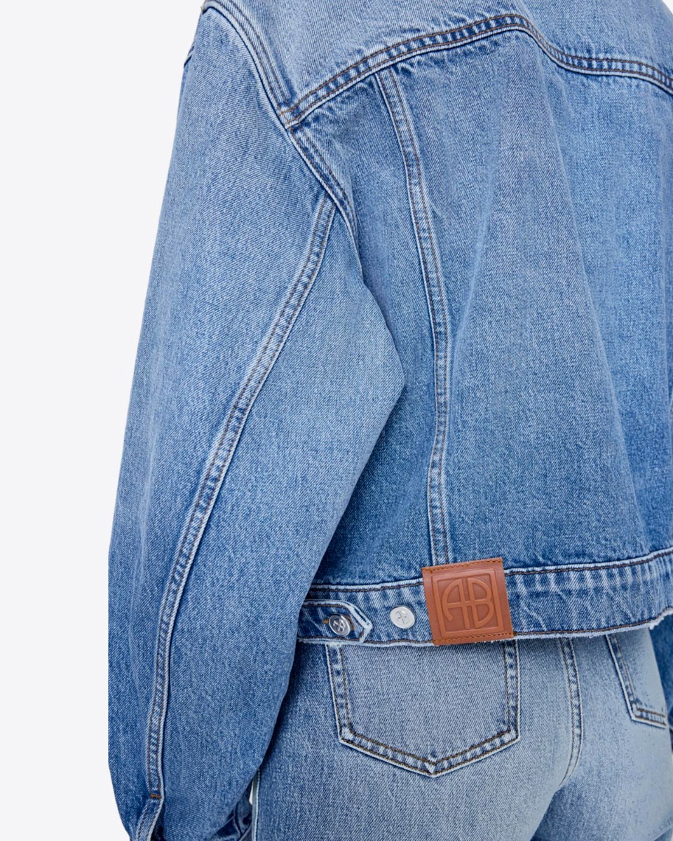 Veste Quincy Anine Bing en denim bleu clair &laquo; Cascade Blue &raquo;. D&eacute;tail de l'&eacute;tiquette avec le logo &laquo; AB &raquo; dans le dos.