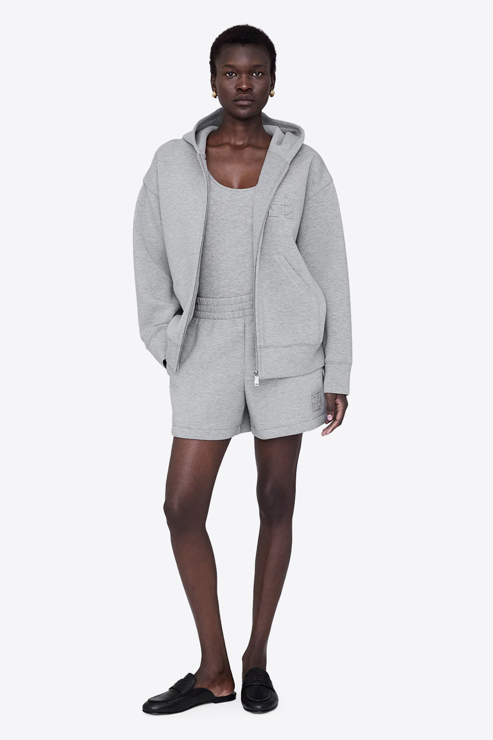 Produit Veste sweatshirt à capuche Bond Anine bing grise. Vue face portée avec un débardeur et un short gris. 