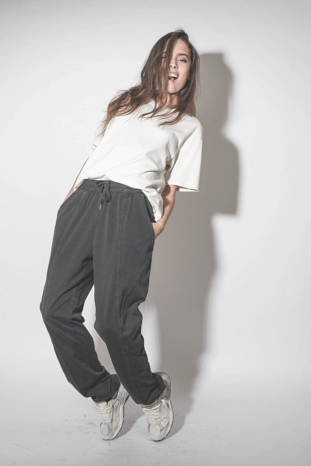 Baskets Running Dad blanche étoile en cuir lisse blanc Golden Goose femme.  Porté avec un jogging en jersey noir.