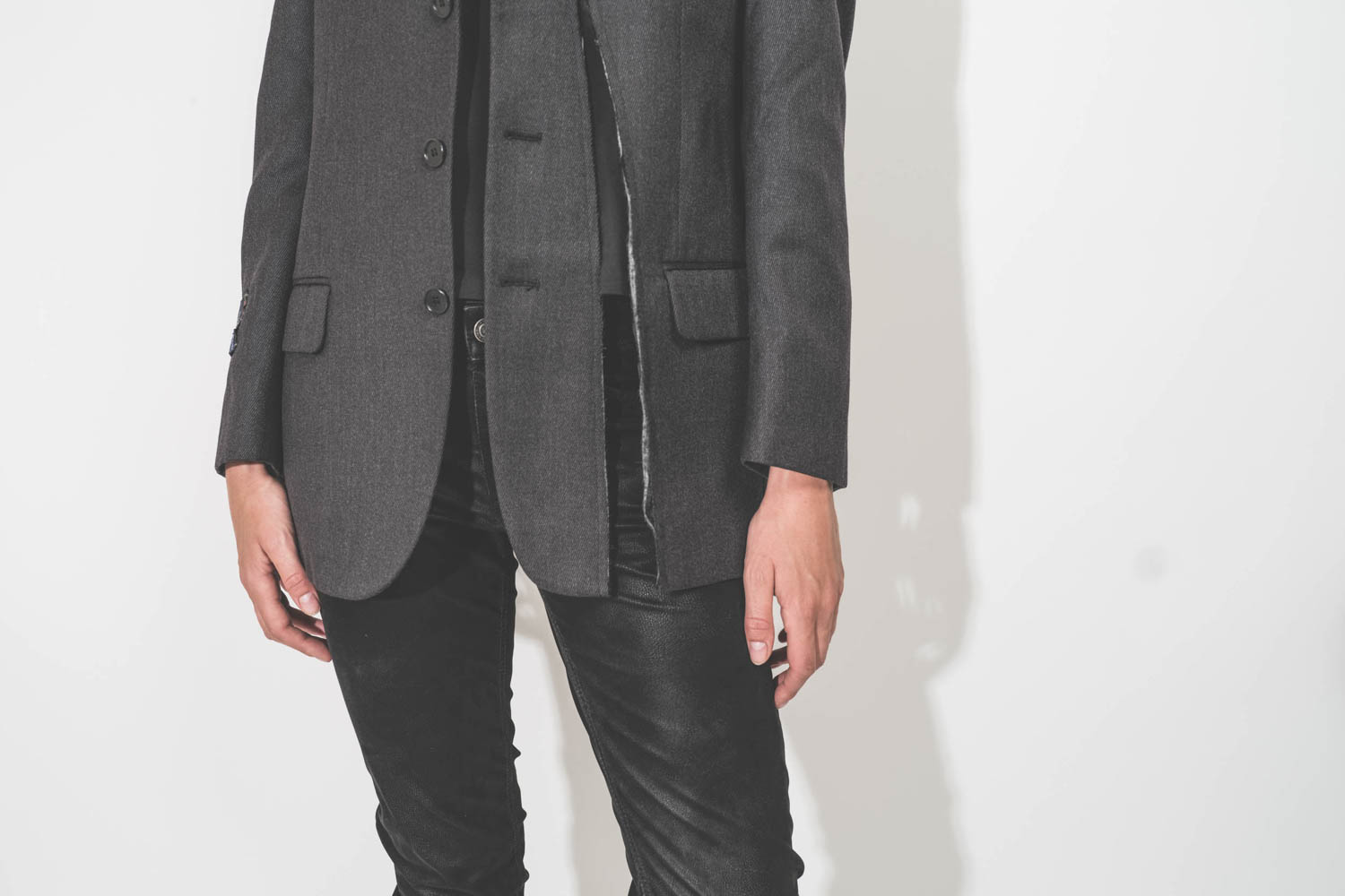 Veste longue anthracite en laine froide, customisée et upcyclée par Yekaterina Ivankova portée de face. Détail de la veste déchirée volontairement devant.