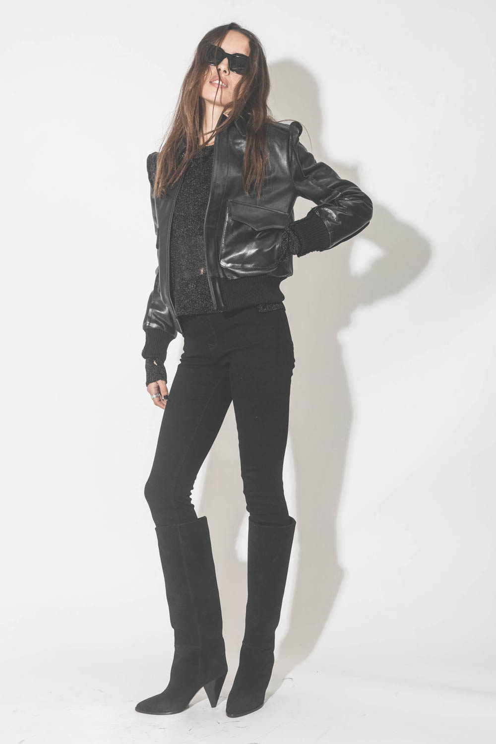 Blouson en cuir brillant noir R13. Porté avec un jeans skinny et des bottes à talons.